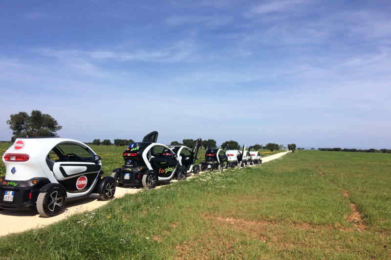 miniauto elettriche tra ulivi e distese di grano in Puglia